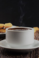 Hot liquid chocolate, in white cup and plate on the table