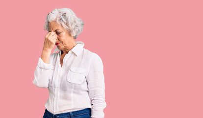 Senior grey-haired woman wearing casual clothes tired rubbing nose and eyes feeling fatigue and headache. stress and frustration concept.