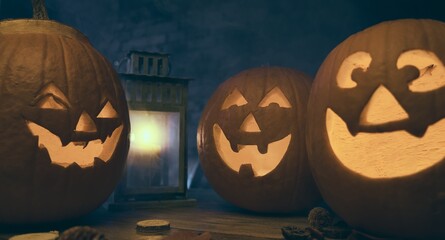 Spooky halloween carved pumpkins, jack o lantern, on wooden table.