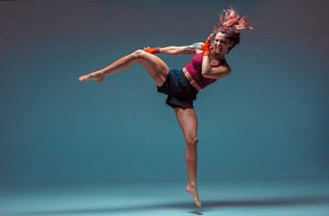 A young female fighter performs a jump kick.