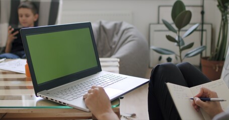 Woman holding computer with green screen