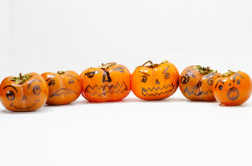 Jack - o ' - lantern, Halloween monsters - muzzles drawn on persimmon fruit. Persimmon is very similar to a pumpkin, the same orange and cheerful.