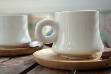 Turkish coffee with foam on top , made of fresh roasted and fine ground coffee beans, served in small ceramic cups on bamboo plates with Turkish delight or bitter chocolate pieces after breakfast