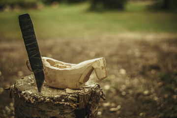 Manufacture of utensils of wood, a wooden mug and a knife on the stump
