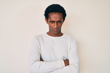 African handsome man wearing casual winter sweater skeptic and nervous, disapproving expression on face with crossed arms. negative person.
