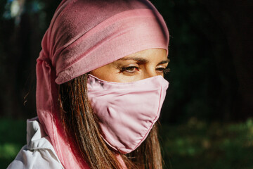 Beautiful Woman wearing pink scarf and pink mask from breast cancer. Lifestyle. Health