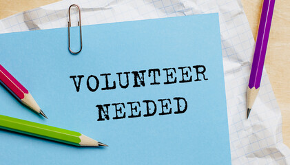 Volunteer Needed text written on a paper with pencils in office