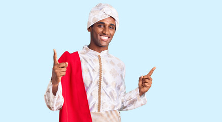 African handsome man wearing tradition sherwani saree clothes smiling confident pointing with...