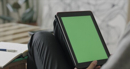 Woman holding tablet computer with green screen