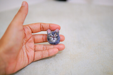 portrait of a grey cat that is embroidered by hand on cloth into a brooch