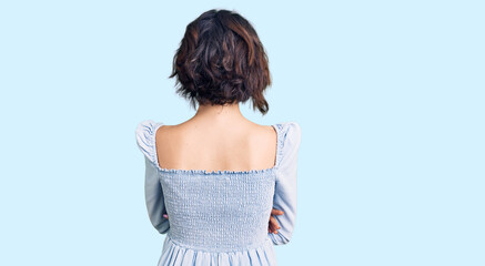 Young beautiful girl wearing casual clothes standing backwards looking away with crossed arms