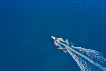 Aerial view luxury motor boat. Drone view of a boat sailing. Travel - image. Motor boat in the sea. Top view of a white boat sailing to the blue sea. Drone view of a boat  the blue clear waters.