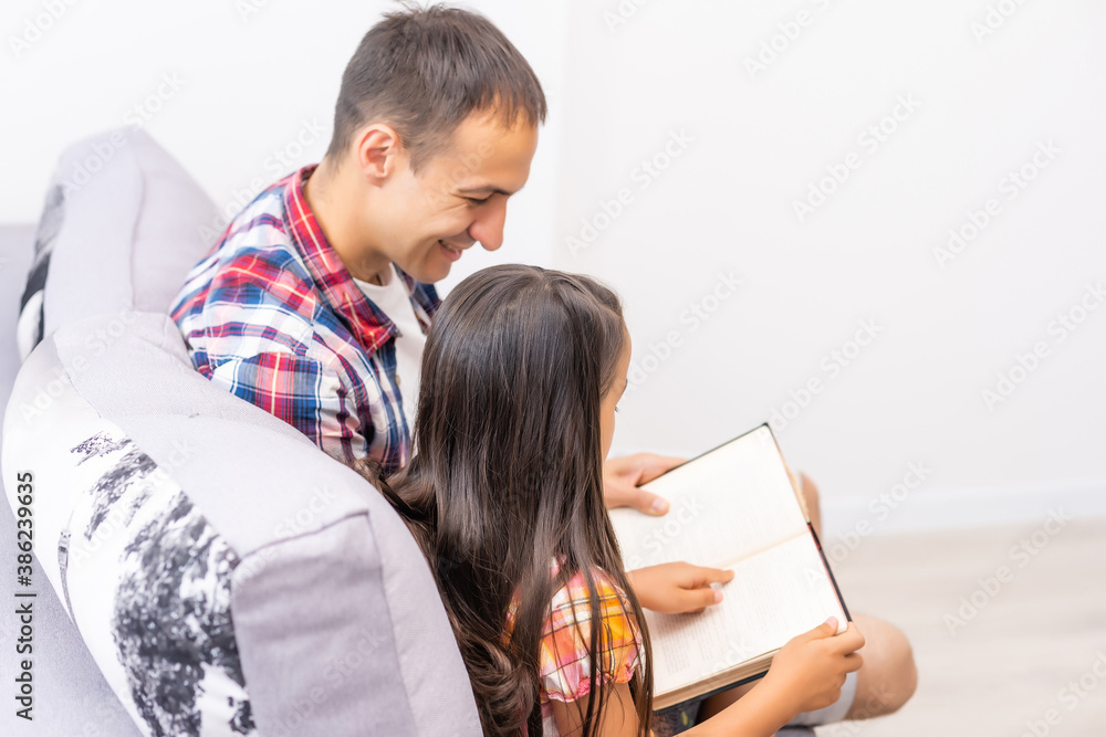 Canvas Prints a young father with his little daughter reads the bible