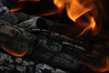 Smoldered logs burned in vivid fire close up. Atmospheric background with flame of campfire....