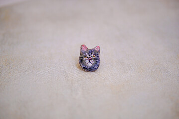 portrait of a grey cat that is embroidered by hand on cloth into a brooch