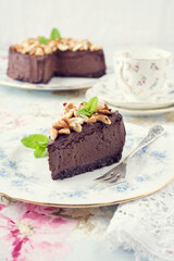 Traditional chocolate pie with cashew nuts offered as close-up on a design bone China plate