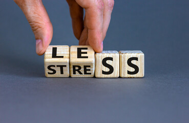 Having less stress or being stress-less. The word 'STRESS' and 'LESS' on wooden cubes. Male hand. ...