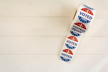 Top view of Roll of I Voted Today stickers on white wooden table with copy space. US presidential election concept