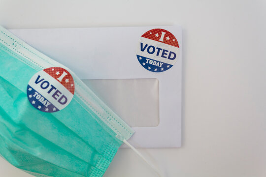 Envelope with voting ballot papers sent by mail and prrotective face mask. Concept of Voting by mail in the USA during coronavirus pandemic - Powered by Adobe