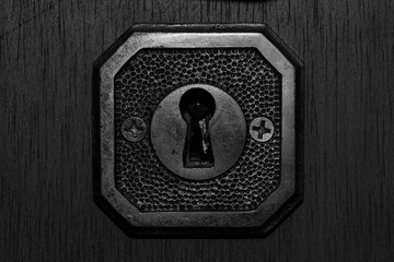 Black and white isolated keyhole on a wood door with details