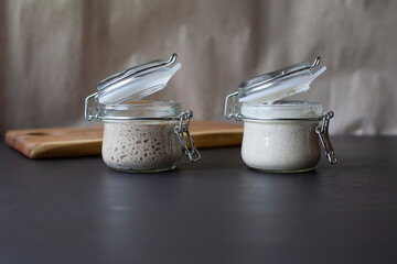 Active rye and wheat sourdough starter in glass jars.