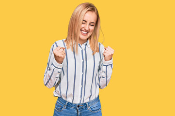 Beautiful caucasian woman wearing casual clothes very happy and excited doing winner gesture with arms raised, smiling and screaming for success. celebration concept.