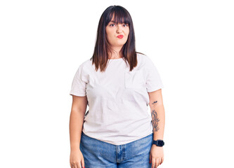 Young plus size woman wearing casual clothes looking sleepy and tired, exhausted for fatigue and hangover, lazy eyes in the morning.