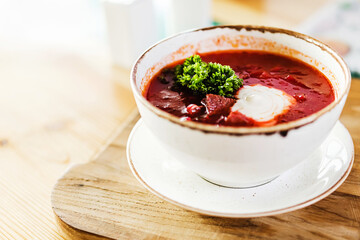 soup borscht with sour cream in a white plate on a wooden Board
