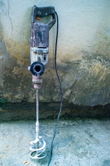 dirty hand electric concrete mixer. repair in the apartment. Mixer attachment for drilling and...