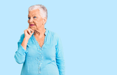 Senior beautiful woman with blue eyes and grey hair wearing summer dress with hand on chin thinking about question, pensive expression. smiling with thoughtful face. doubt concept.