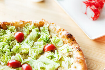 pizza with tomatoes and salad in a cafe on the table