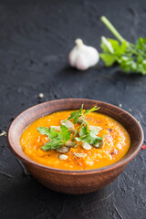 Delicious healthy pumpkin soup, herbs, and ingredients for the dish. Creative atmospheric decoration