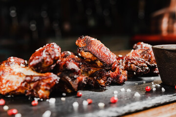 grilled chicken wings on a black Board with sauce