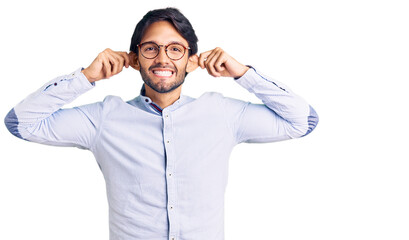 Handsome hispanic man wearing business shirt and glasses smiling pulling ears with fingers, funny gesture. audition problem