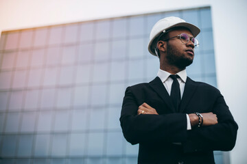 African engineer in front of a skyscraper.