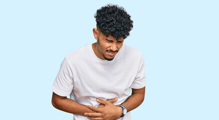 Young arab man wearing casual white t shirt with hand on stomach because indigestion, painful...