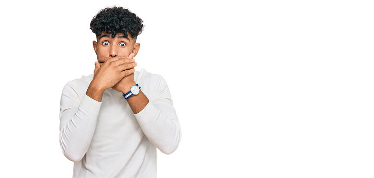 Young arab man wearing casual winter sweater shocked covering mouth with hands for mistake. secret concept.