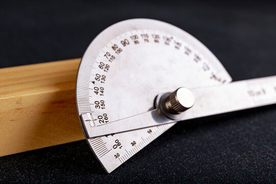 A protractor for measuring angles in a carpentry workshop. Accessories for measuring and drawing in a carpentry shop.