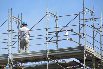 Uomo al lavoro sul cantiere edile in primavera - business