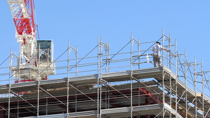 Uomo al lavoro sul cantiere edile in primavera - business