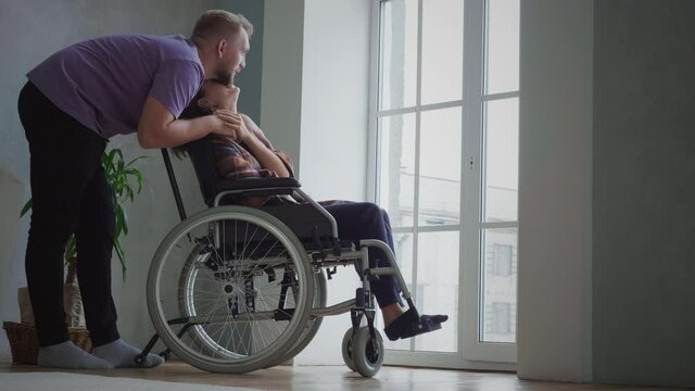 Man embraces his disabled wife