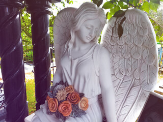 Figure of a praying angel. A very ancient stone statue. Death. Sad angel as symbol of pain, fear...