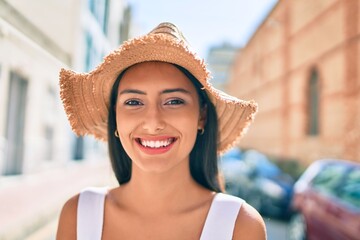 Young latin girl wearing summer style and smiling happy at street of city.