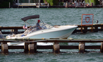 White motorboat with a black Bimini top.