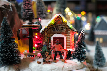 Miniature of winter scene with Christmas houses, people, trees, Christmas concept.