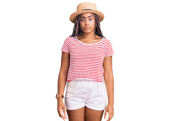 Young african american woman with braids wearing summer hat relaxed with serious expression on face. simple and natural looking at the camera.