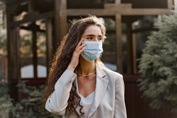 Girl in medical mask in green park. Coronavirus covid-19 quarantine concept.