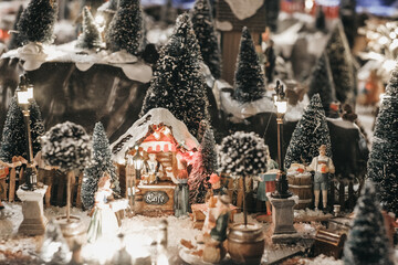 Miniature of winter scene with Christmas houses, people, trees, Christmas concept.