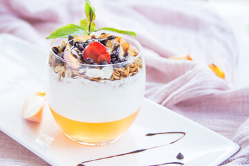 Healthy strawberry, peach and walnut parfait in a glass on a white background