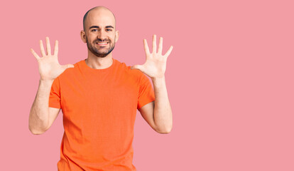 Young handsome man wering casual t shirt showing and pointing up with fingers number ten while smiling confident and happy.